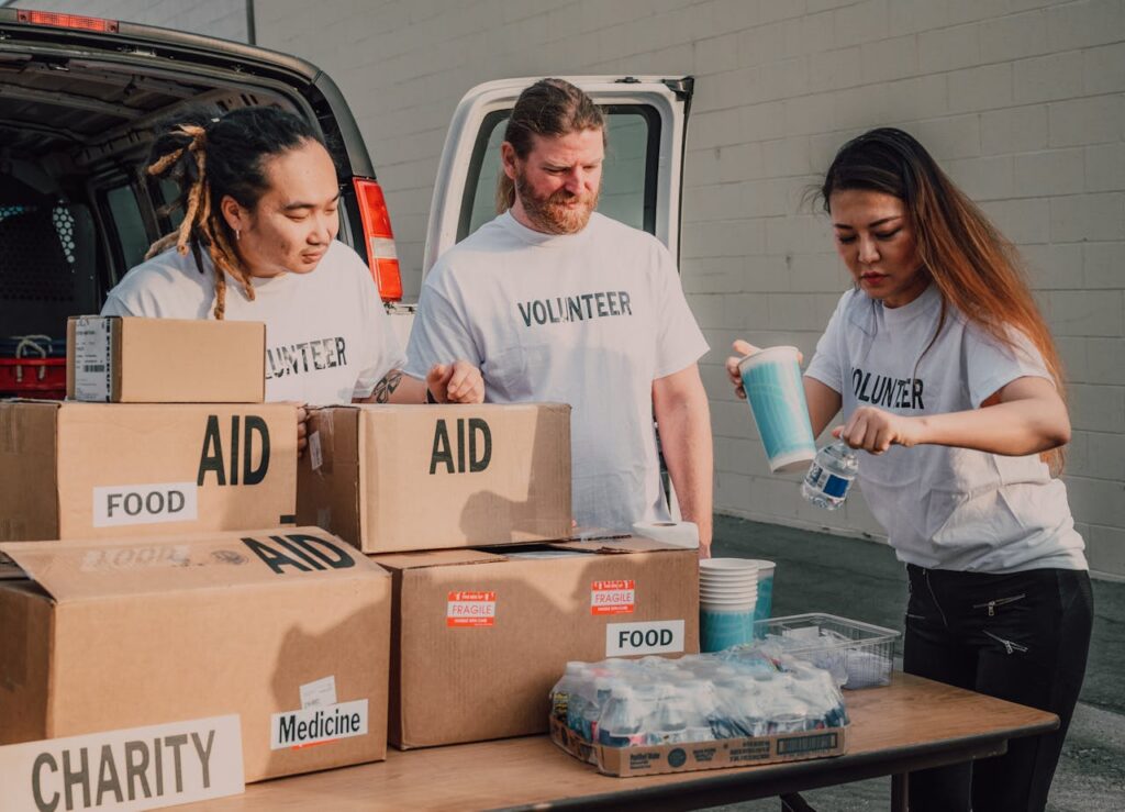 Accueil Volunteers sort aid and food boxes for a charity drive, promoting togetherness and social good.